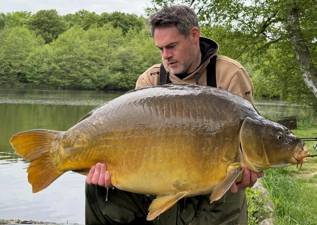 Guest holding a huge fish that he caught.